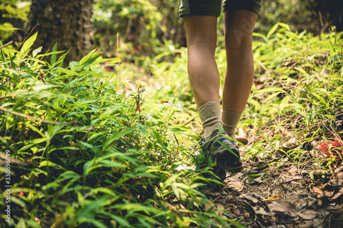 Young woman hiker legs walking on trail in spring mountains