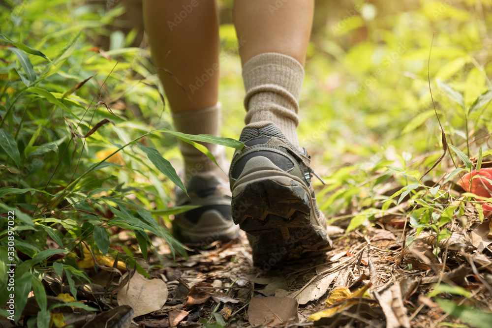 Young woman hiker legs walking on trail in spring mountains Young woman hiker legs walking on trail in spring mountains