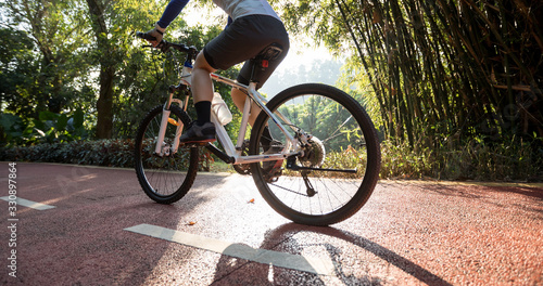 Woman cycling on bike path at sunrise park