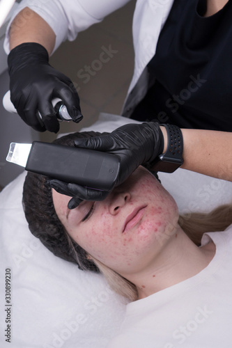 Hardware cosmetology. Cosmetologist does moisturizing conductive gel and conducts ultrasonic cleaning procedure face. Spa. Cleansing skin pores. Acne treatment. Professional skin care.