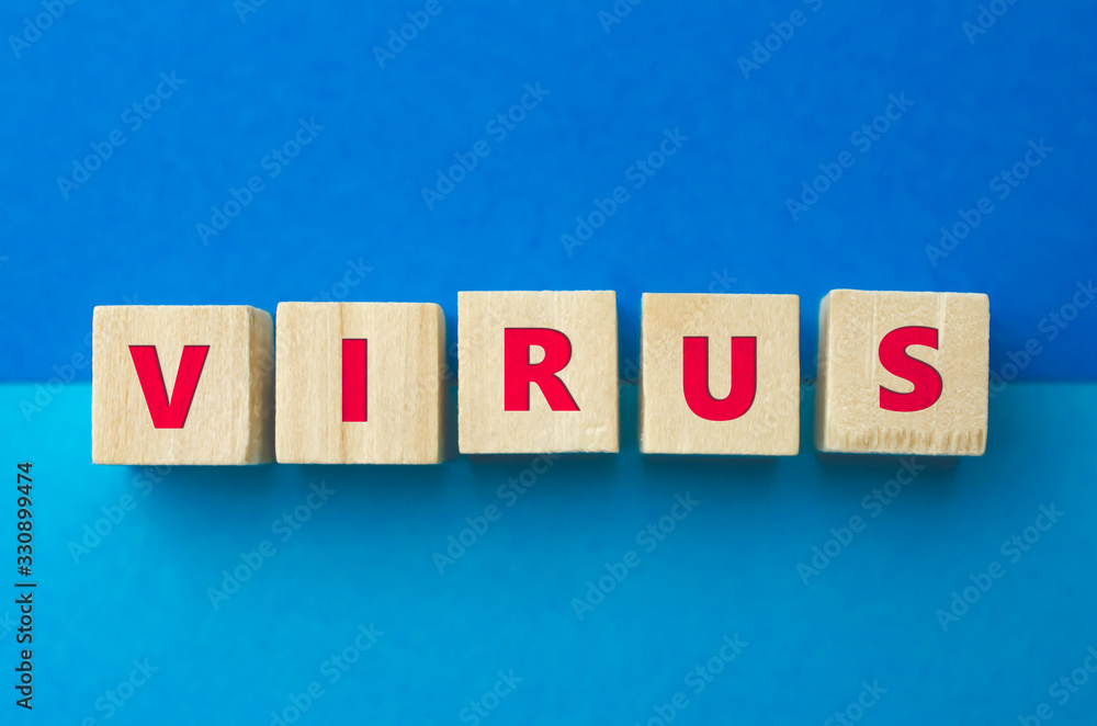 Obraz premium Virus inscription on wooden cubes on the blue background. Diseases, epidemics and pandemics concept