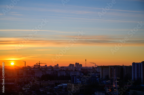 Photo of a morning sunrise in the sky above the city and houses on a clear spring morning