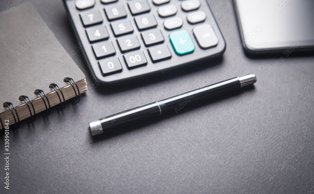 Pen and calculator on black background. Pen and calculator on black background.