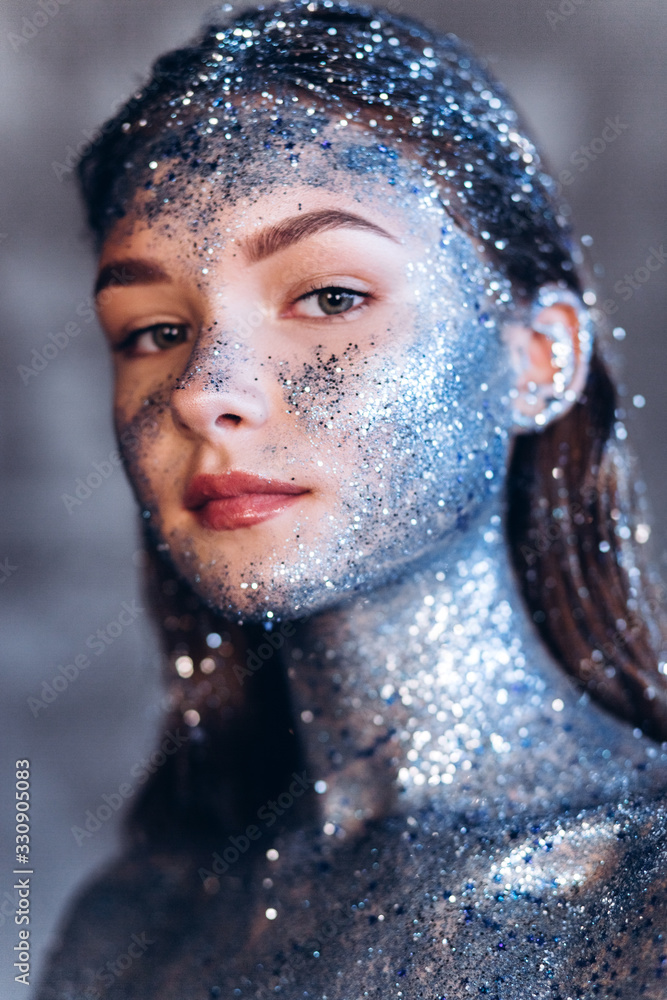 Close up portrait of young fashionable model with art make up with blue sparkles. Fashion, art, beauty concept Close up portrait of young fashionable model with art make up with blue sparkles. Fashion, art, beauty concept