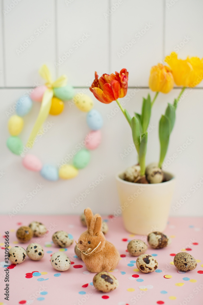 Easter wreath, bunny, quail eggs and tulips in a flower pot