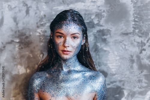 Close up portrait of young fashionable model with art make up with blue sparkles. Fashion  art  beauty concept
