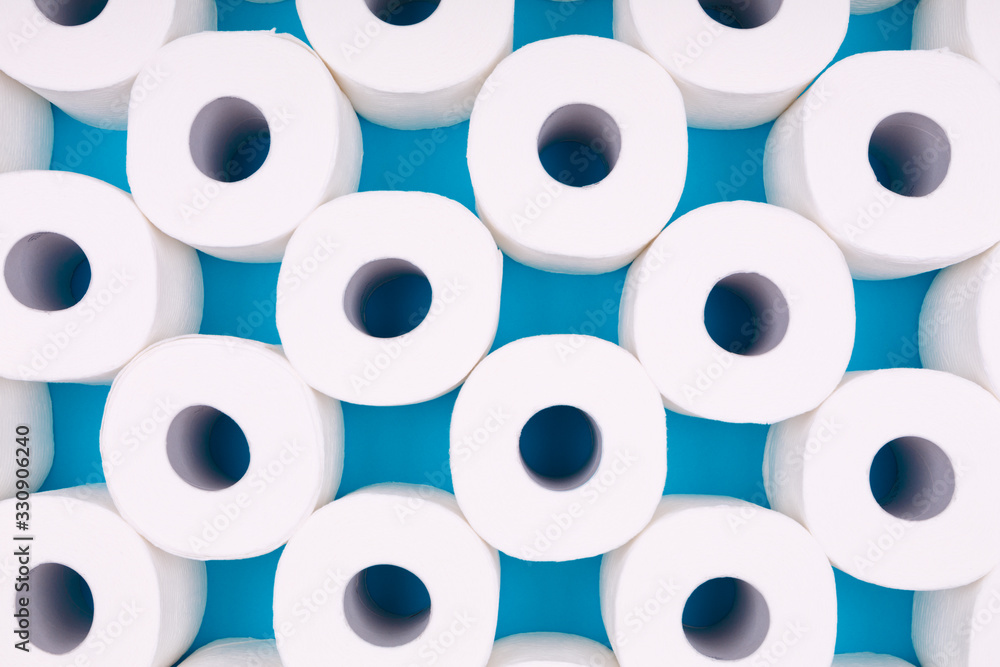 Pattern of toilet paper rolls on the bright blue background. Coronavirus pandemic panic shopping concept. Bright monochrome drop Pattern of toilet paper rolls on the bright blue background. Coronavirus pandemic panic shopping concept. Bright monochrome drop