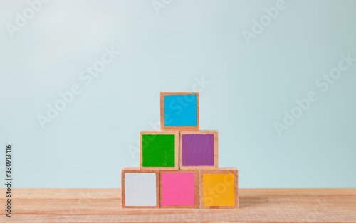 Wooden blocks of many colors arranged on a wooden table, Pastel tones.