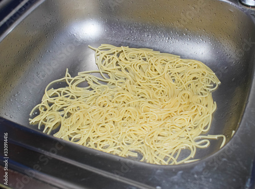 Obraz na plátne Cooked spaghetti dumped in the sink by carelessness when draining the water from the pan