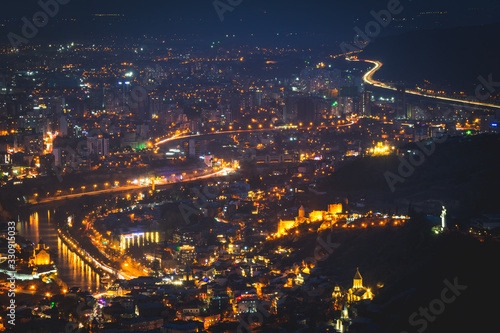 Mtkvari river and surounded areas with smog in the air in Tbilisi at night. Lightrails. Pollution and traffic in Georgia. Sakartvelo.2020 photo