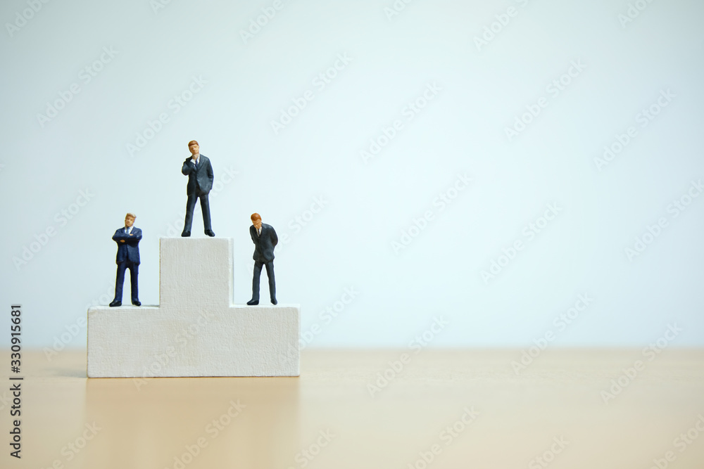 Business conceptual photo – miniature of businessman stands on wooden podium Business conceptual photo – miniature of businessman stands on wooden podium