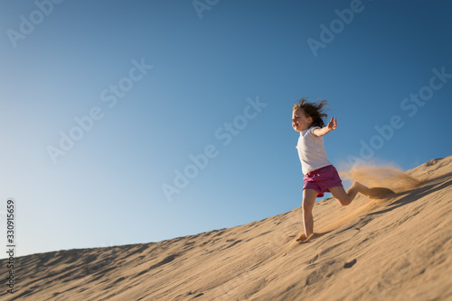 Child running down sand dune
