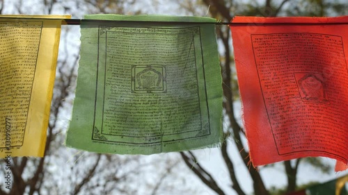 Beautiful shot of colorful Buddhist flags fluttering in the wind on a rope during a bright sunny day photo