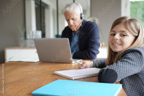 Man working from home and watching kid out of school