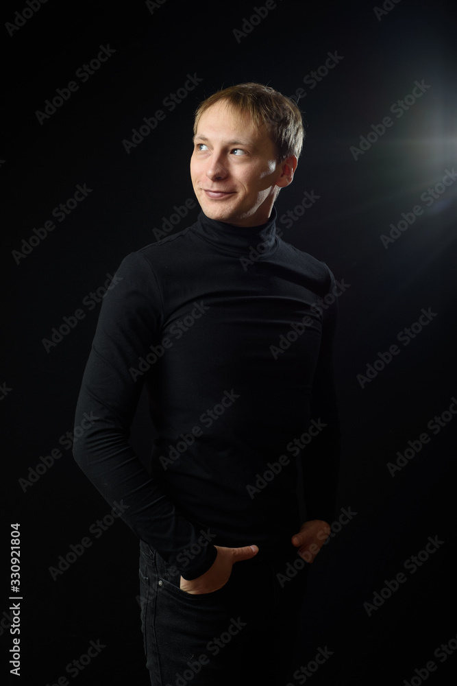 Naklejka premium Portrait of determined goodlooking man wearing black shirt, black background.