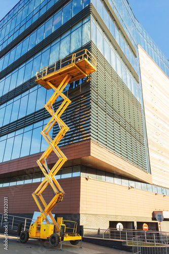 Workers on a Scissor Lift Platform at a construction site. Men at work. Scissor lift platform ensures safe operation at height.