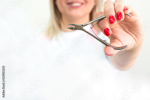 Cuticle forceps. Hands hold a manicure and pedicure tool. copy space. Beauty Industry Concept