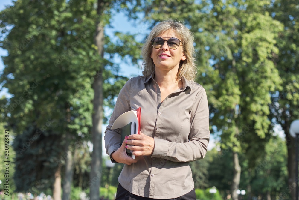 Business confident mature woman walking with documents outdoor Business confident mature woman walking with documents outdoor