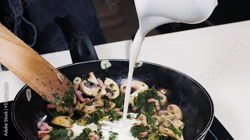In stewed ingredients: mushrooms, spinach and garlic pour milk