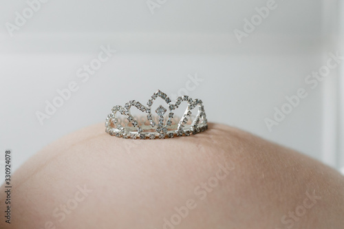 Pregnancy baby belly newborn expectation. toy crown on the belly 