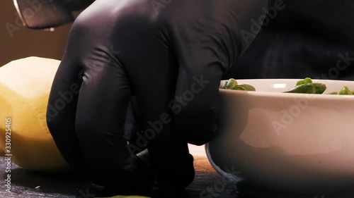 The cook takes the dill from the table and transfers it to the cutting board, touching the potato tuble.