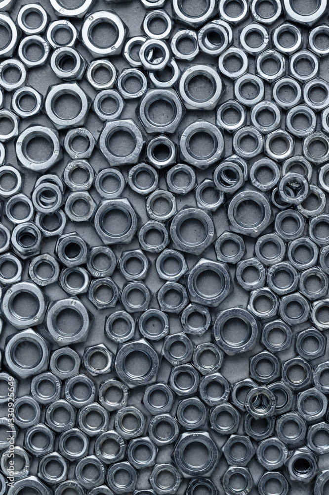 Shiny nuts of various sizes on a granite surface, abstract industrial background Shiny nuts of various sizes on a granite surface, abstract industrial background