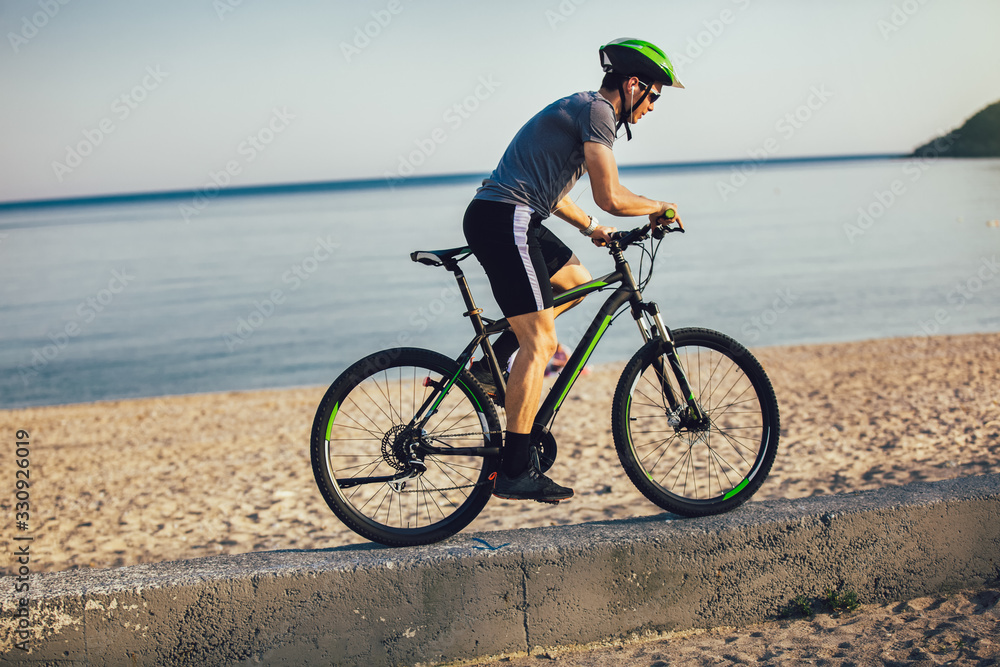 Man ride mountain bike on the beach. Sport and active life concept. Man ride mountain bike on the beach. Sport and active life concept.