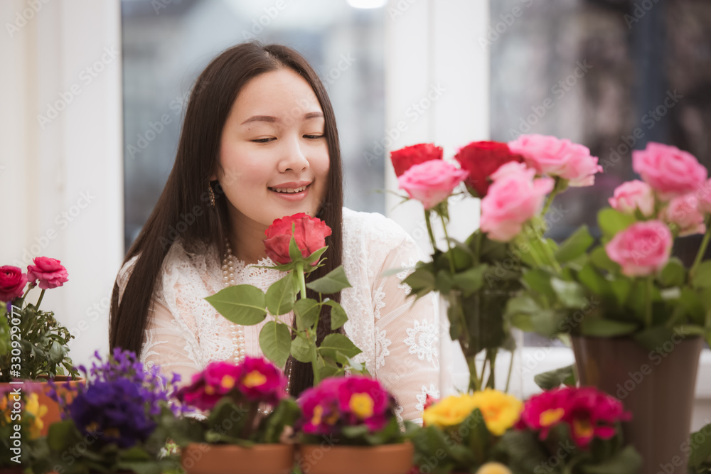 Woman Preparing to trim red and pink roses and beautiful flower arrangements in the home, flower arrangements with vase for gift-giving for Valentine's Day and Business in family on the on table