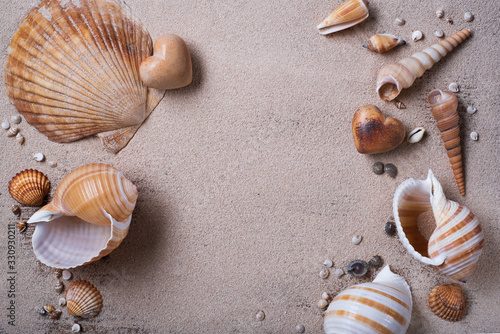 Shells and stone hearts on the sand.  © VLADISLAV