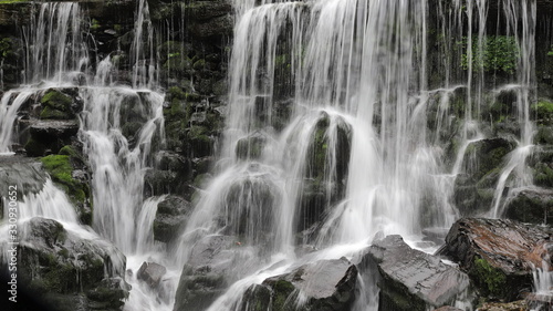 Close-up of waterfalls rushing over mossy rocks © Wheat field