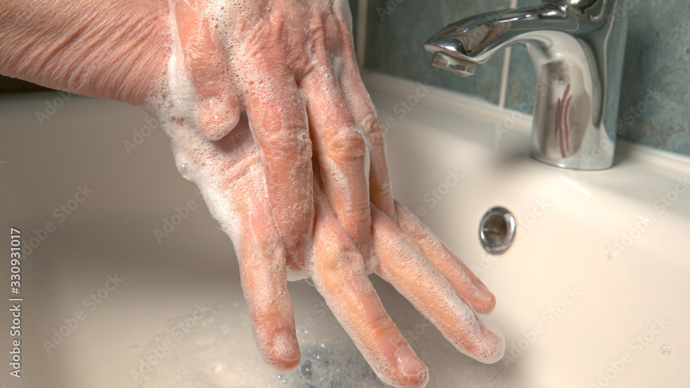 Fototapeta premium CLOSE UP, DOF: Unrecognizable person thoroughly washes their hands with soap.