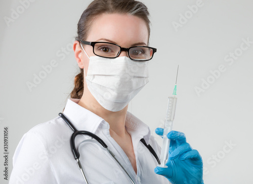 female doctor or nurse with a pulled up syringe