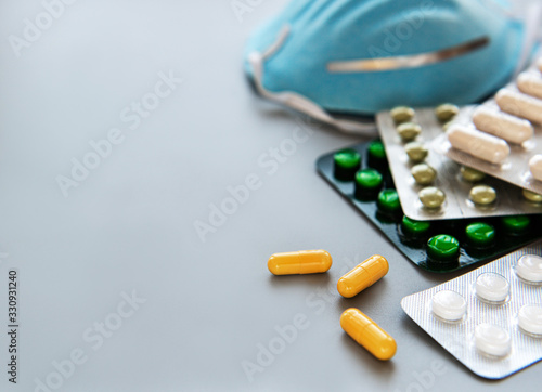 Blue medical mask and medicine pills