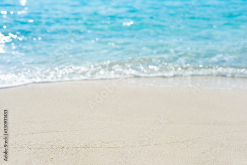 Summer vacation concept with sand and blurred tropical beach background