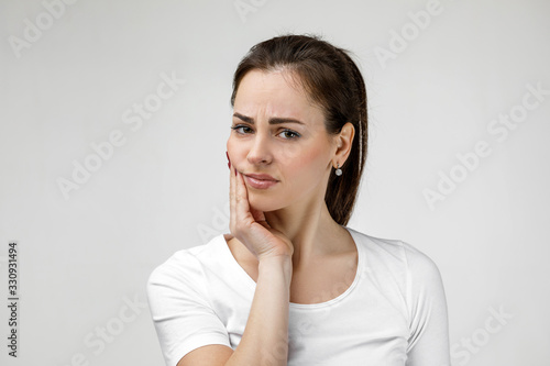 young sad woman suffering from tooth pain, caries. girl having toothache. Dental health and care concept photo