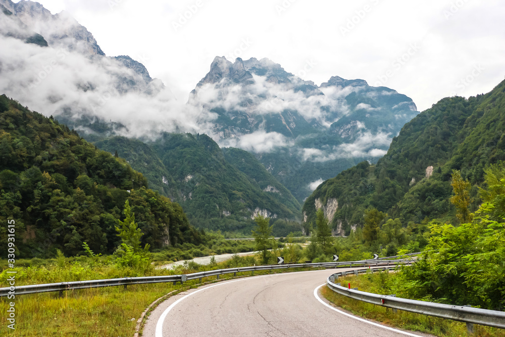Mountain road in Belluno province. Cloudy day in italian mountains. Mountain road in Belluno province. Cloudy day in italian mountains.