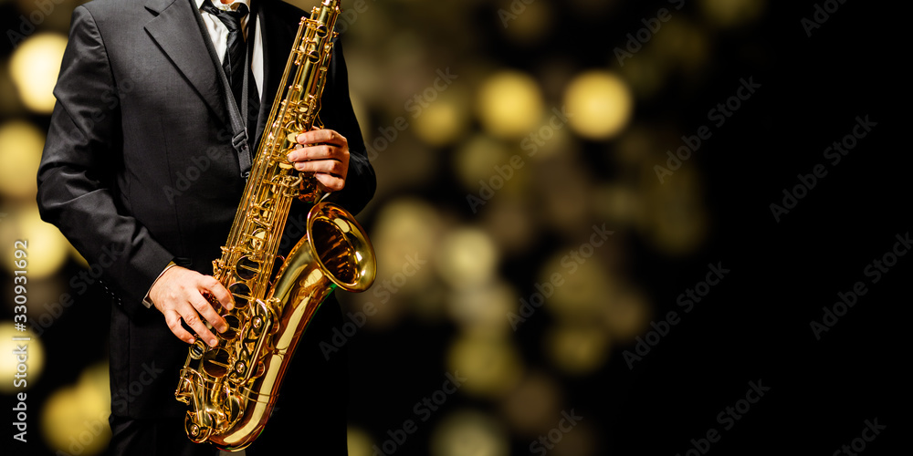 Naklejka premium Playin' sax isolated at the left border of a black background