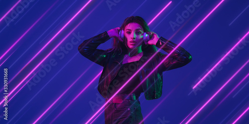 Creative emotions and neon lines on blue background, flyer, proposal. Caucasian young woman listen to music. Concept of human emotions, facial expression, sales, ad, music, hobby. Modern art.