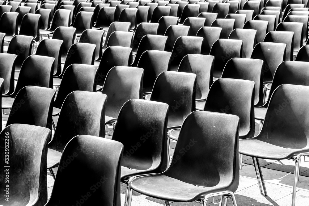 Rows of empty black chairs, prepared for event. Rows of empty black chairs, prepared for event.