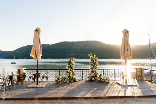 arch of flowers for ceremony in background of lake photo