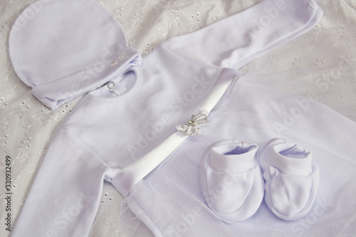 white baby clothes for baptism,white dress with booties and hat for the girl for baptism © retbool
