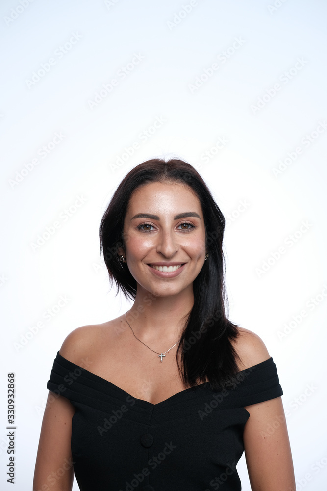 A large portrait of a middle-aged woman (30-35 years old) with dark hair and brown eyes in a black dress on a light background. A large portrait of a middle-aged woman (30-35 years old) with dark hair and brown eyes in a black dress on a light background.