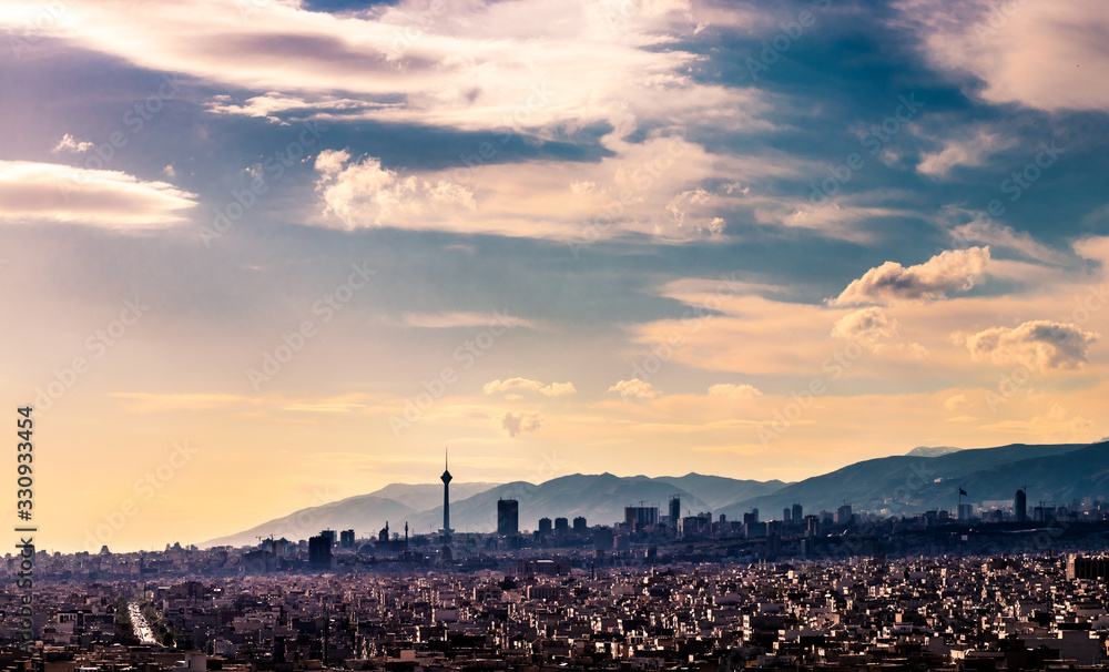 Tehran skyline in a beautiful cloudy day with golden hour light Tehran-Iran cityscape with Milad tower in photo and white clouds and lovely blue sky