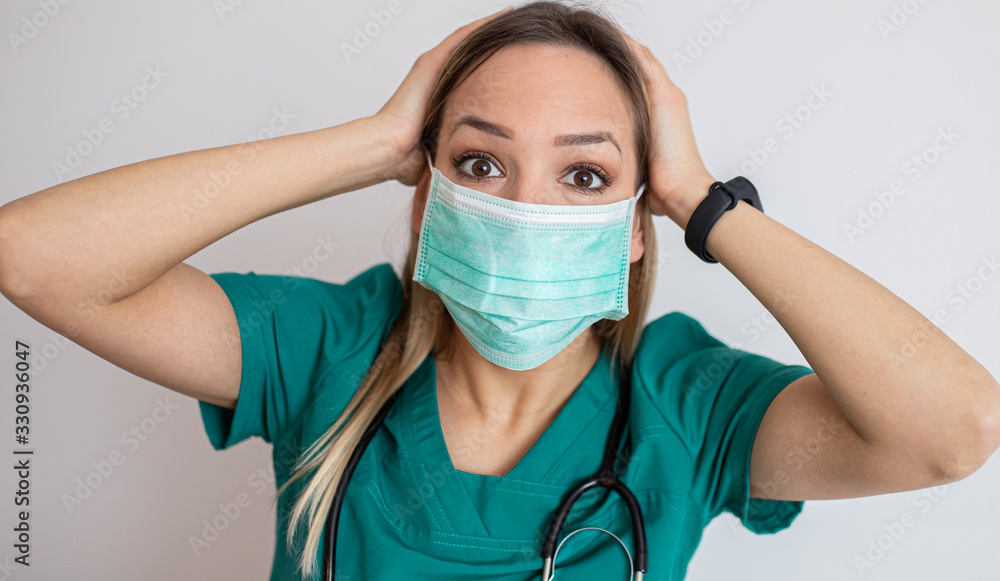 Young nurse feeling extremely shocked and surprised, anxious and panicking, with a stressed and horrified look against white wall – stock image Young nurse feeling extremely shocked and surprised, anxious and panicking, with a stressed and horrified look against white wall – stock image