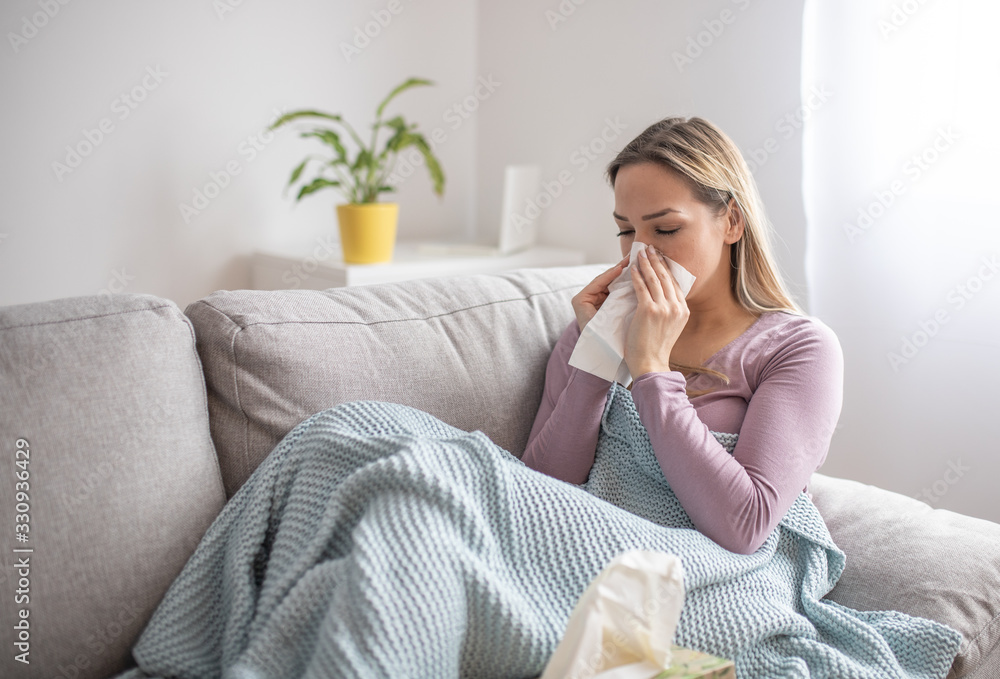 Sick woman blowing nose, sitting under the blanket. Sick woman with seasonal infections, flu, allergy lying in bed. Sick woman covered with a blanket lying in bed with high fever and a flu, resting. Sick woman blowing nose, sitting under the blanket. Sick woman with seasonal infections, flu, allergy lying in bed. Sick woman covered with a blanket lying in bed with high fever and a flu, resting.