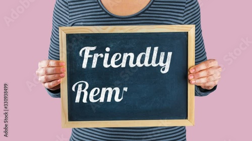 Woman holding small blackboard with animated text Friendly Reminder