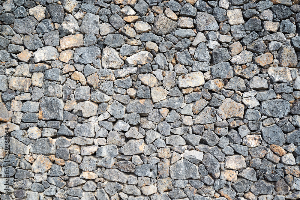 Beschaffenheit einer grauen und schwarzen Lava-Natursteinmauer als abstrakter Hintergrund Beschaffenheit einer grauen und schwarzen Lava-Natursteinmauer als abstrakter Hintergrund