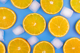  Slices of orange and ice cubes on a blue background.Summer background.