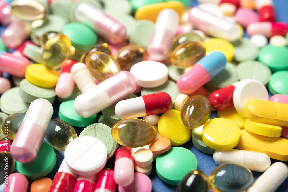 Pills and capsules on a blue background, close-up. Concept of medicine and health Pills and capsules on a blue background, close-up. Concept of medicine and health