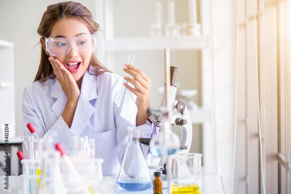 Attractive happiness scientist woman lab technician assistant analyzing sample in test tube at laboratory. Medical, pharmaceutical and scientific research and development concept. Attractive happiness scientist woman lab technician assistant analyzing sample in test tube at laboratory. Medical, pharmaceutical and scientific research and development concept.